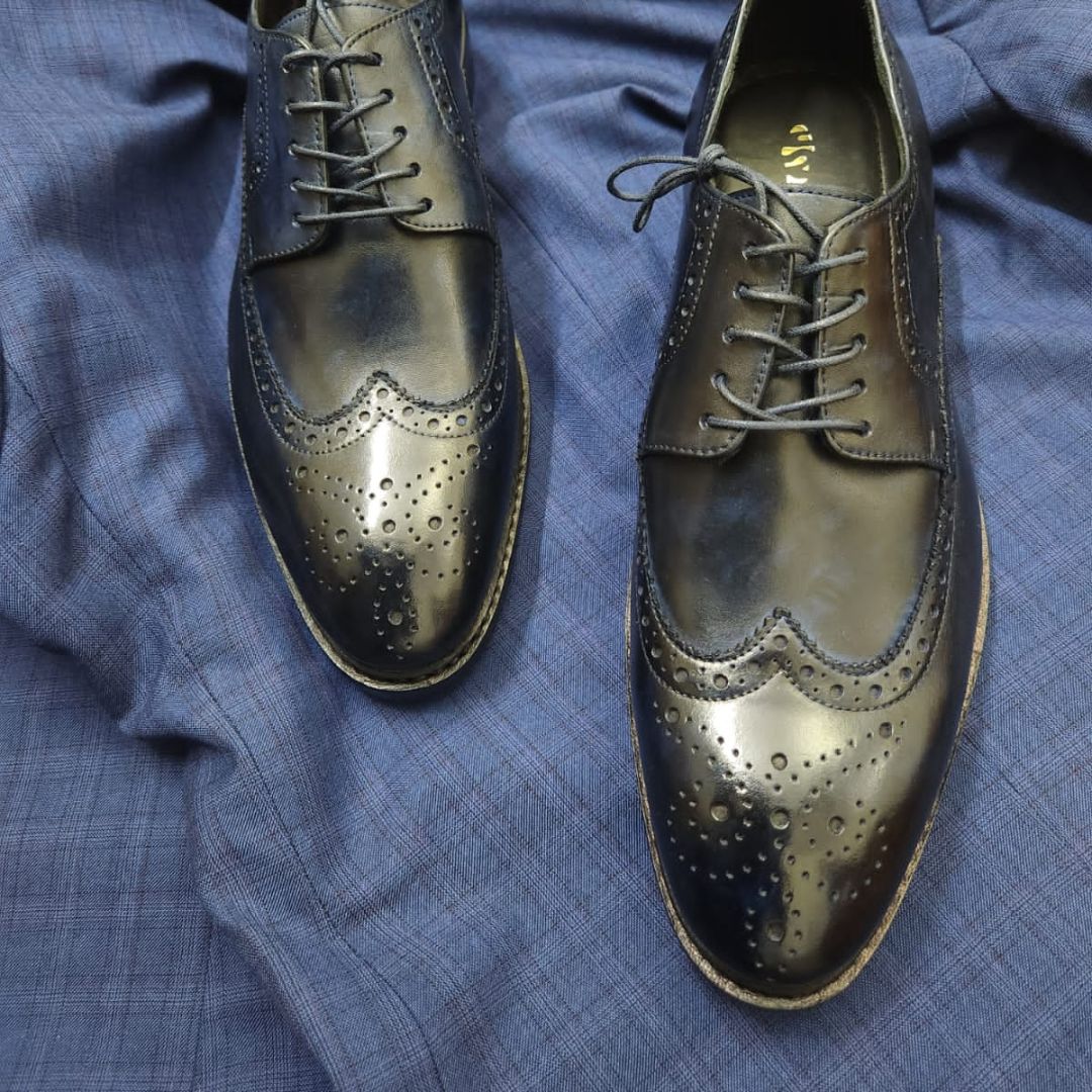 Goodyear welted wingtip navy leather derby shoe with medallion